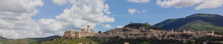 Panorama, das das historische Zentrum einer charmanten umbrischen Stadt hervorhebt, umgeben von üppigen Hügeln.