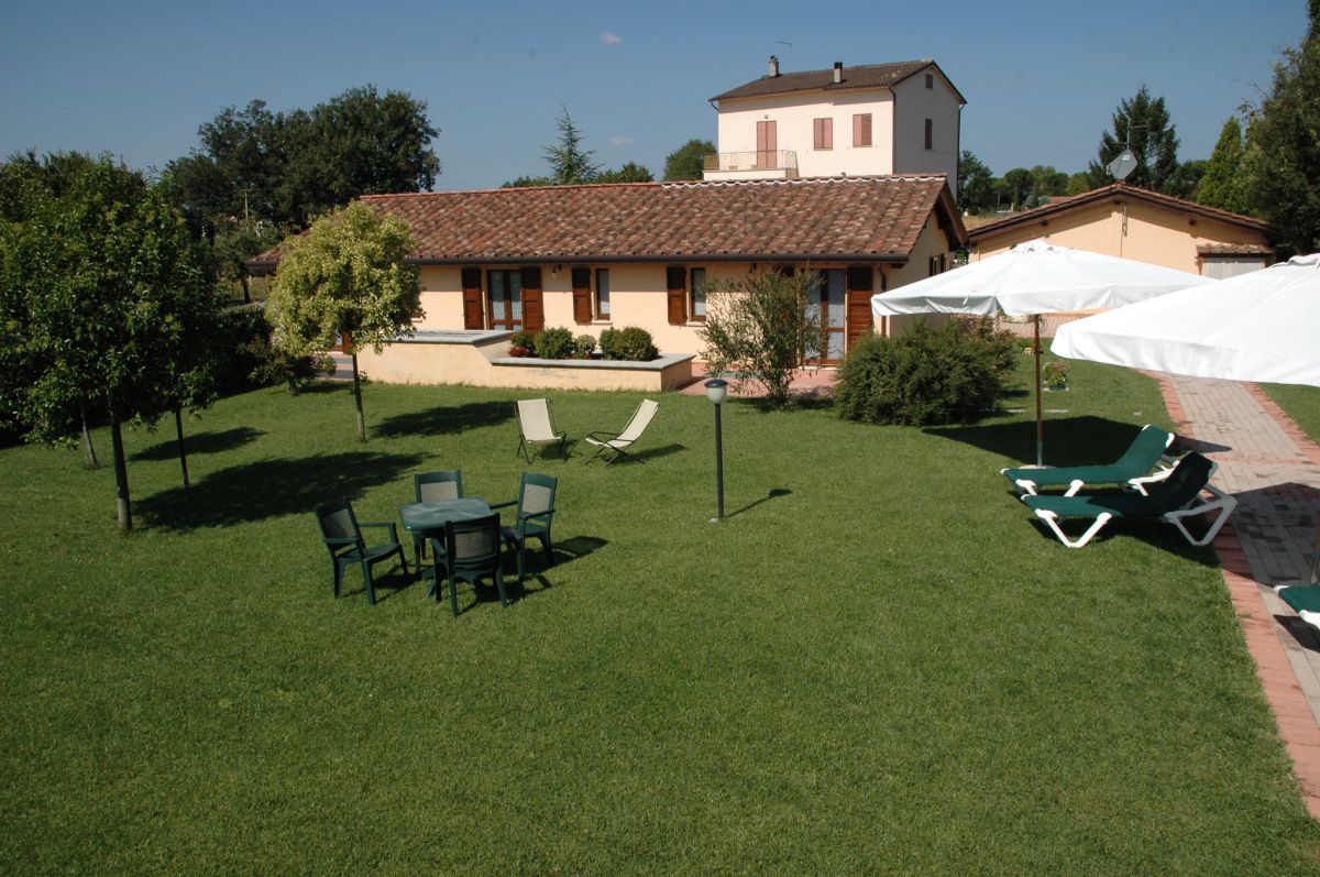 Un residence tranquillo con appartamenti circondati da alberi, piscina e ampio giardino.