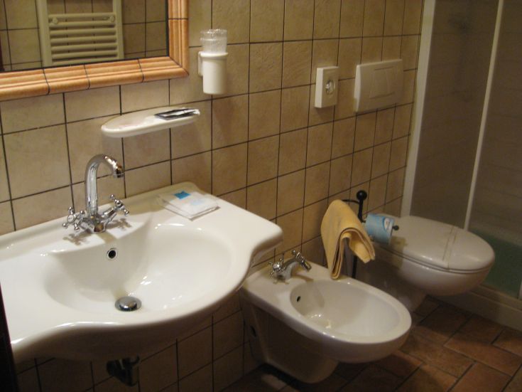 Bagno funzionale con lavabo, bidet e doccia, caratterizzato da un'atmosfera calda e accogliente.