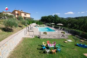 Agriturismo mit Pool, umgeben von grünen Flächen, ideal zum Entspannen und für Kinderaktivitäten.