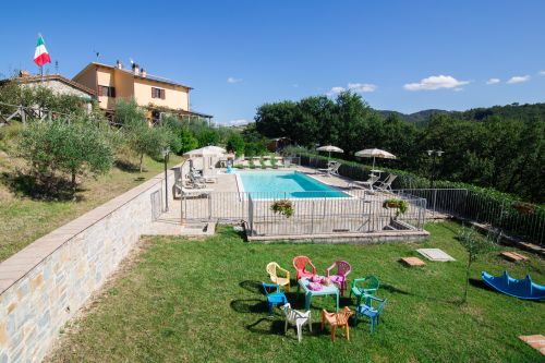 Agriturismo mit Pool, umgeben von grünen Flächen, ideal zum Entspannen und für Kinderaktivitäten.