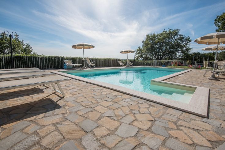 Ein ruhiger Bauernhof mit Schwimmbad, umgeben von Grün und Blumen, ideal für entspannende Momente.