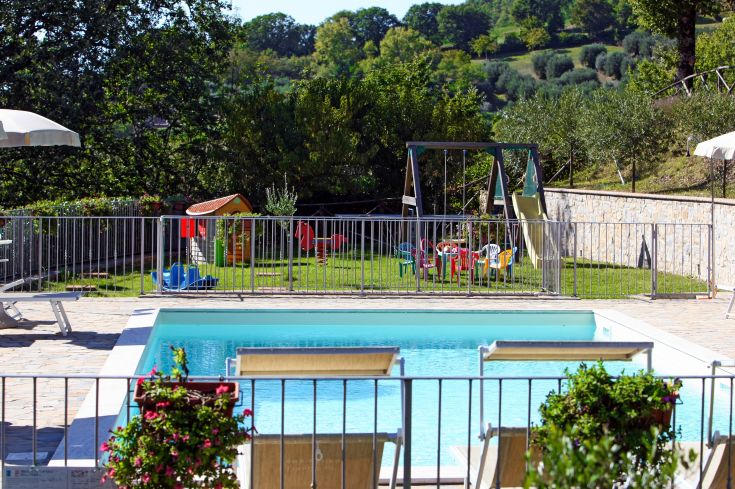 Bauernhof mit Pool und Spielplatz, umgeben von Grünflächen, perfekt für Familien und Entspannungsmomente.