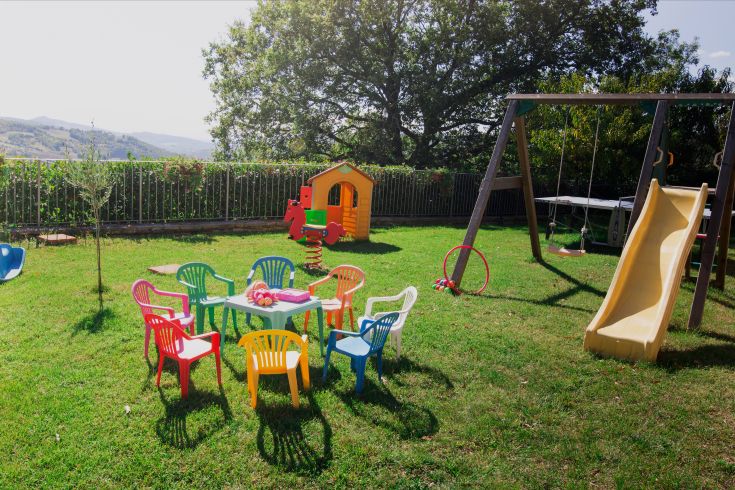 Spielbereich im Freien in einem sicheren Garten mit Spielen und Geräten für Kinder.