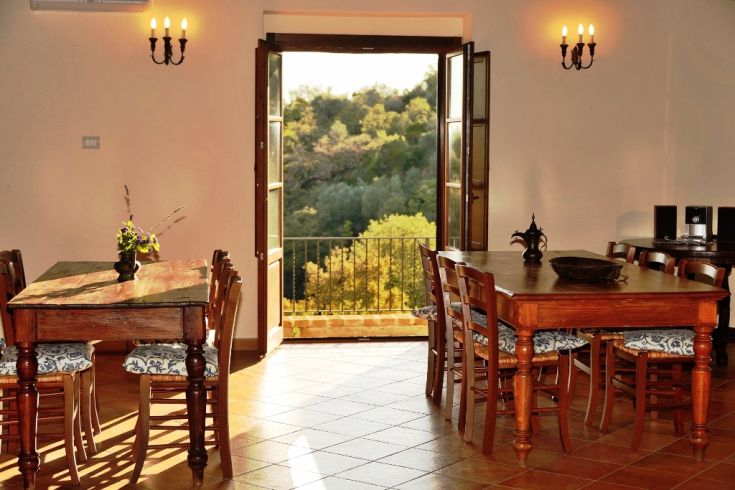Cozy common room with hillside views, featuring wooden furniture. A perfect space for events and relaxation.