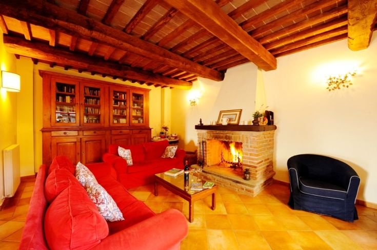Cozy living room featuring a fireplace and red sofas, creating a welcoming atmosphere in an elegant building.