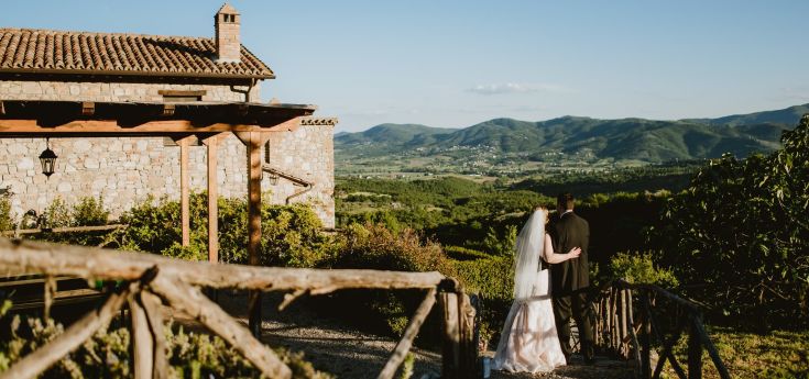 A photo of newlyweds in a hilly setting, surrounded by trees and nature, creating a serene atmosphere.