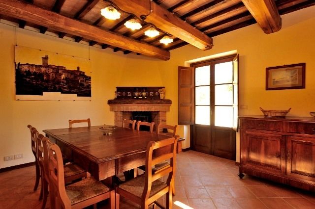 Spacious dining room with a wooden table and large windows allowing plenty of natural light.