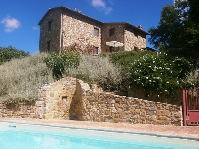 A stone farmhouse located in a green area, surrounded by outdoor spaces and a calm atmosphere.