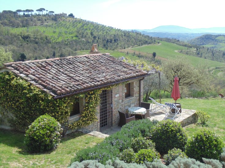 A small villa immersed in nature, surrounded by green hills and vineyards in Umbria.