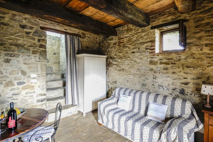 An interior space featuring stone walls, furnished with a sofa and dining table, perfect for relaxation and socializing.