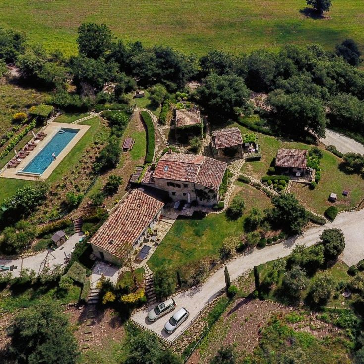 View of a property with a pool surrounded by typical Umbrian greenery.