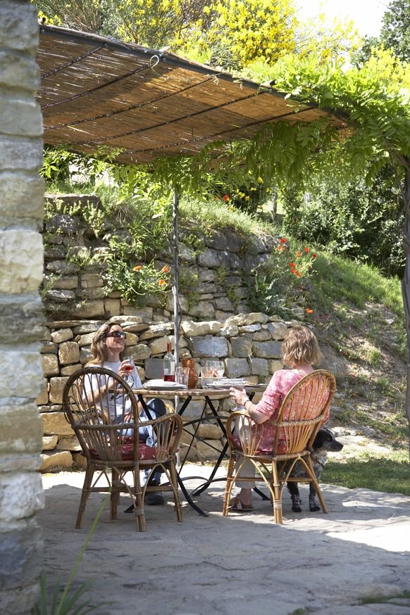 Two smiling women take a break in a cozy outdoor space.