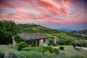 A villa surrounded by greenery, glowing in the warm color of the Umbrian sunset.