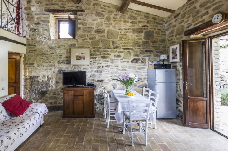 Interior of a palace featuring stone walls, wooden furniture, and a table set for a meal.