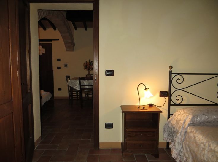 A simple room with a warm light and a view of Todi, located in an Umbrian agriturismo.