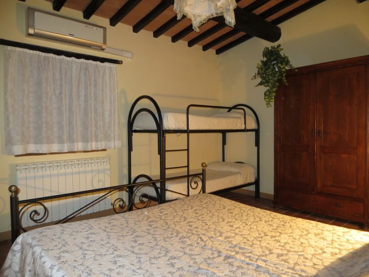 Cozy room with a double bed and bunk beds, providing a peaceful and welcoming atmosphere.