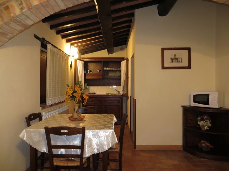 Countryside agriturismo stay with a wooden table, decorative flowers, and rustic style details.