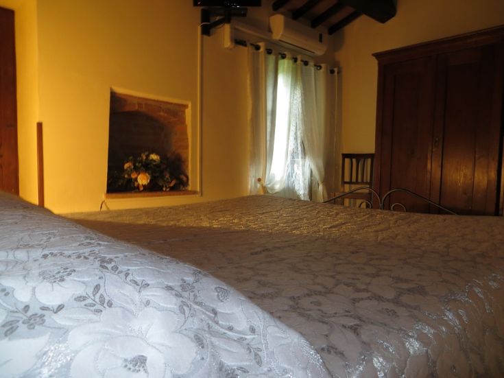 Bright room with a window providing natural light, simple furnishings, and historic details.