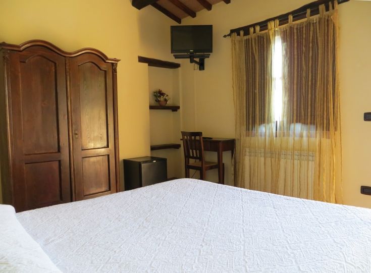 Cozy agriturismo room in Umbria, featuring simple furnishings and a relaxing atmosphere, equipped with essential comforts.