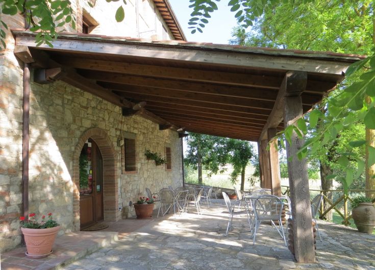 An outdoor area of a farm stay, surrounded by greenery and overlooking the Umbrian countryside.