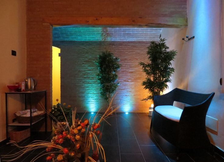 A cozy and tranquil little space, adorned with plants, soft lighting, and simple furnishings.