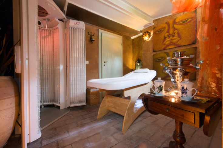 Un'area dedicata al relax, con lettino per massaggi e alcune attrezzature per il benessere, in un ambiente confortevole.