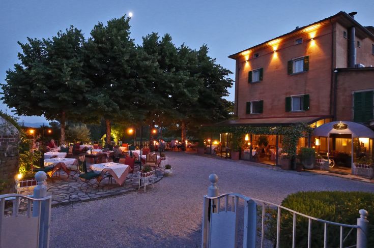 Villa ottocentesca con ristorante, circondata dal verde e con un'illuminazione delicata.