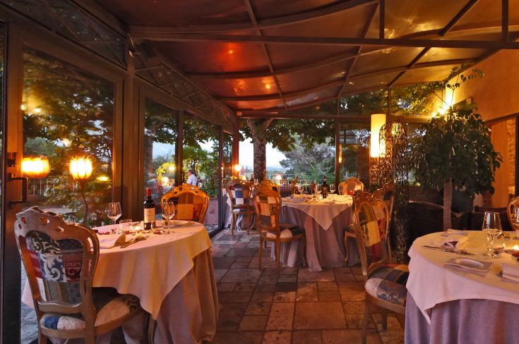 Ristorante con un'atmosfera accogliente, adatto a cene intime, caratterizzato da decorazioni semplici e vista su uno spazio verde.