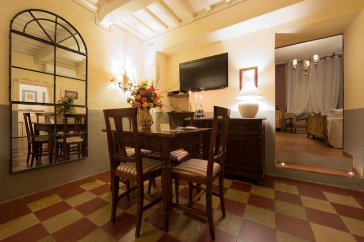 Ampia sala da pranzo con mobili vintage e uno specchio di grandi dimensioni che arreda l'ambiente.