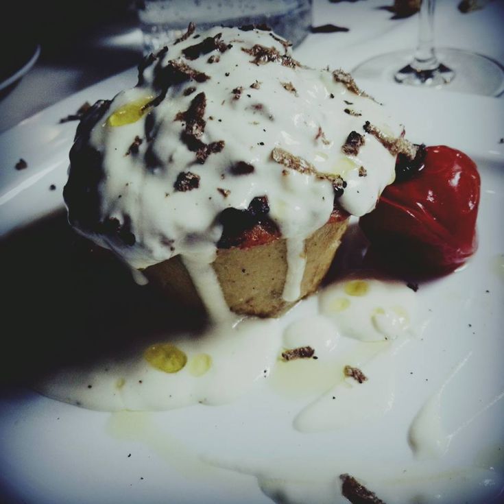 Dessert raffinato con salsa chiara e un pomodoro rosso. Un'armonia di sapori nel piatto.