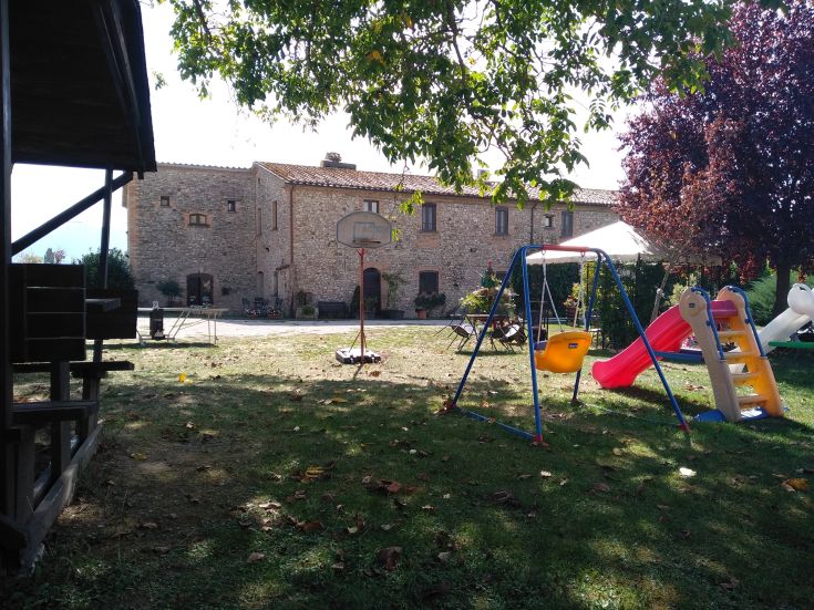 Spielerische Aktivitäten auf einer großen grünen Wiese, mit einem Steingebäude im Hintergrund.