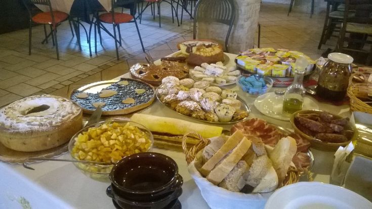 Auswahl an frischen umbrischen Gerichten und traditionellen Süßigkeiten, präsentiert in einem einfachen und einladenden Ambiente.