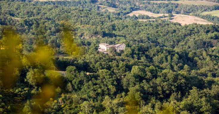 An ancient convent nestled in a natural setting of green hills and forests, perfect for tranquil moments in Umbria.