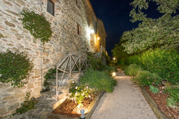 A medieval building surrounded by greenery, perfect for peaceful walks in Umbria.