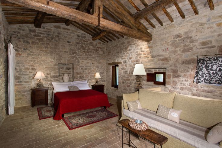 Cozy room with stone walls and simple furniture, perfect for a peaceful stay.