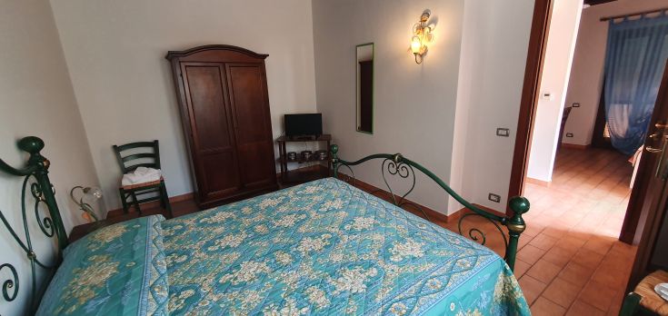 Chambre simple avec un lit à baldaquin et des détails décoratifs.