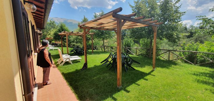 Un panorama d'une zone verte avec des structures assises et des parasols, immergé dans la tranquillité de la nature.