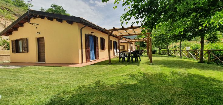 Bâtiment entouré d'arbres, avec un jardin et une zone extérieure idéale pour se détendre.