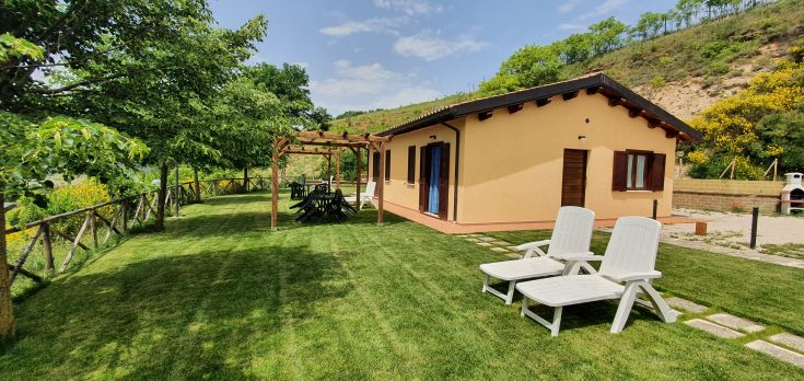 Un bâtiment entouré d'un jardin soigneusement entretenu et d'une véranda pour se détendre en extérieur.
