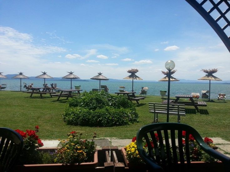 A peaceful corner by Lake Trasimeno, featuring sunbeds and umbrellas for a relaxing moment.