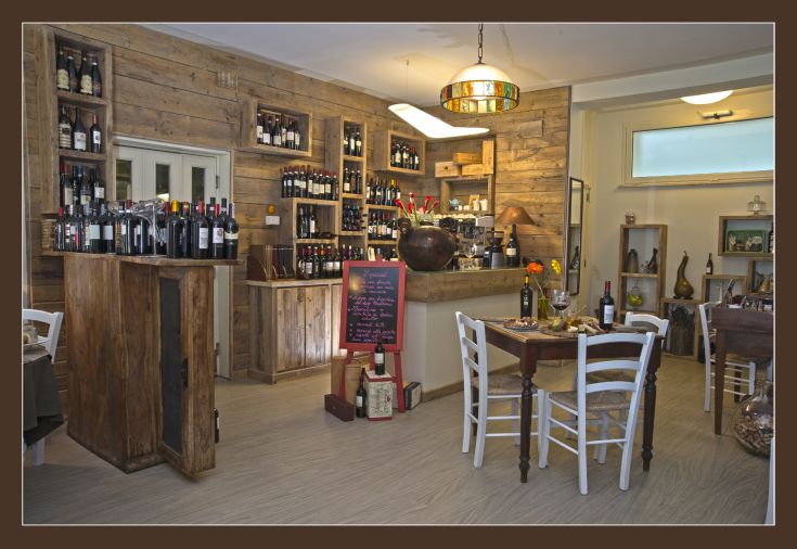 Interno di un edificio con scaffali in legno, che espongono una varietà di vini.