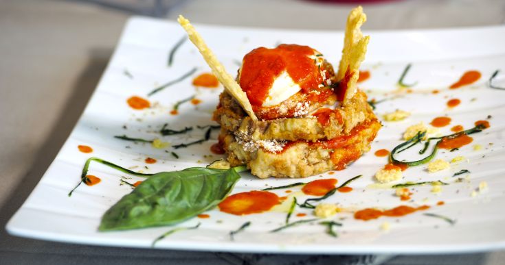 Un piatto ben presentato con una salsa leggera e foglie di basilico come guarnizione.