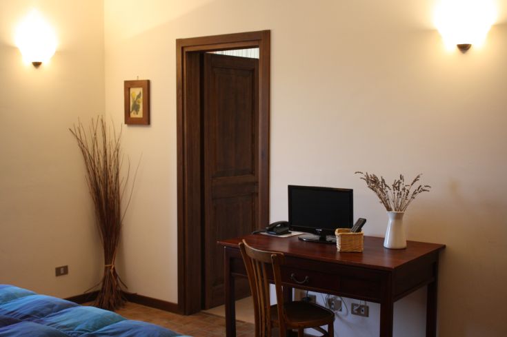 Innenansicht eines Agrartourismus mit einem einfachen Schreibtisch und schlichten Dekorationen.