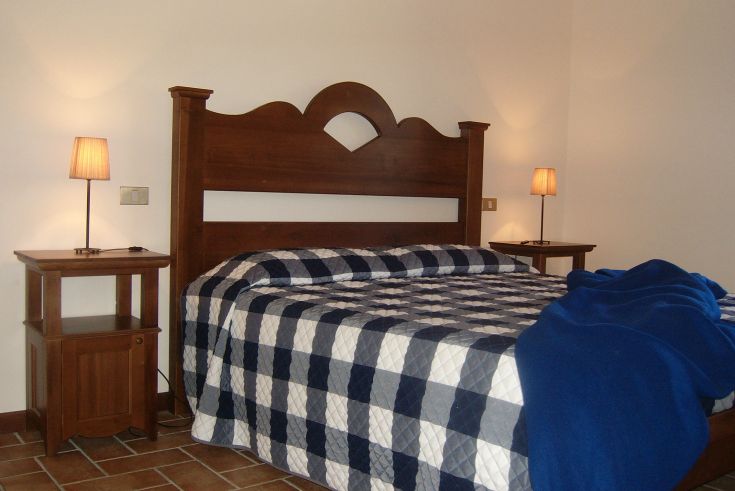 Einfaches Zimmer mit Doppelbett und sanfter Beleuchtung, perfekt für einen ruhigen Aufenthalt.