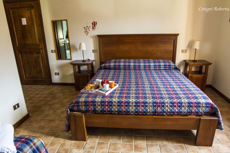 Einfache Zimmer mit Doppelbett und rustikalen Details, perfekt für einen kurzen Aufenthalt auf dem Land.