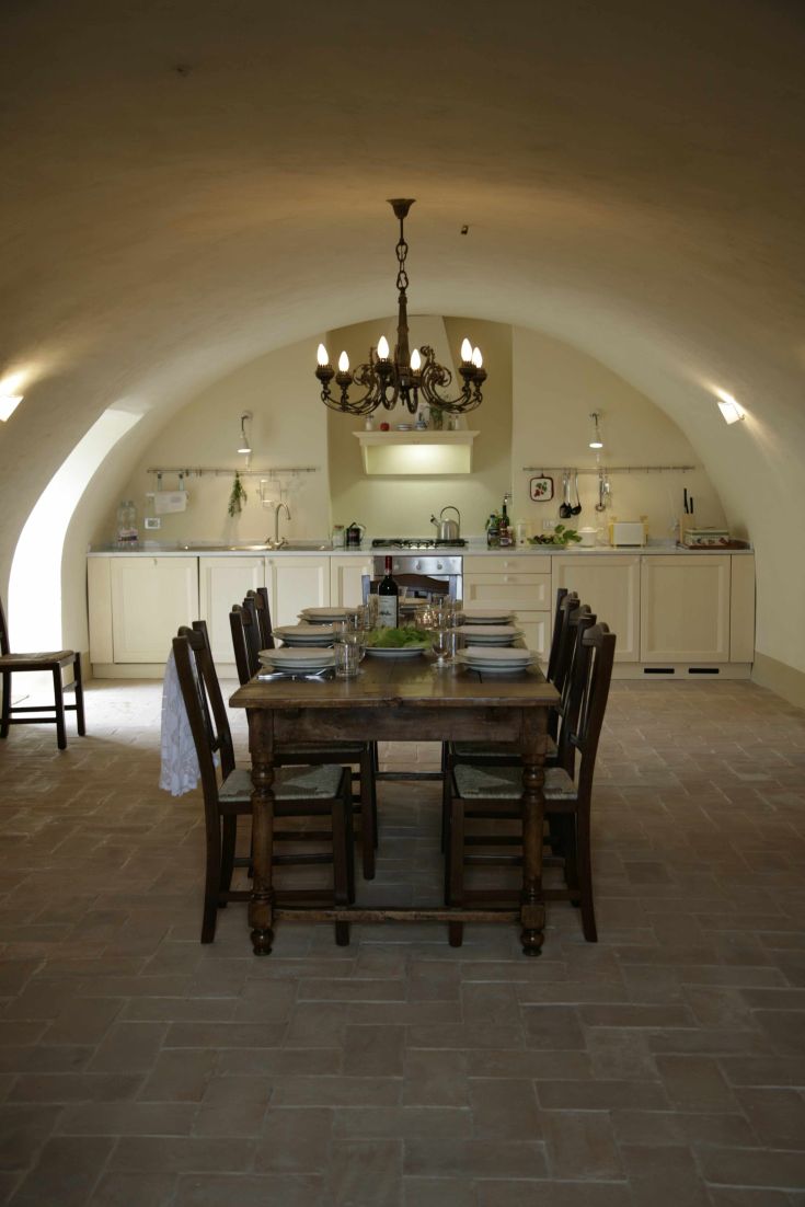 Una cucina ampia e luminosa in stile rustico, dotata di un grande tavolo perfetto per cene tra amici e familiari.