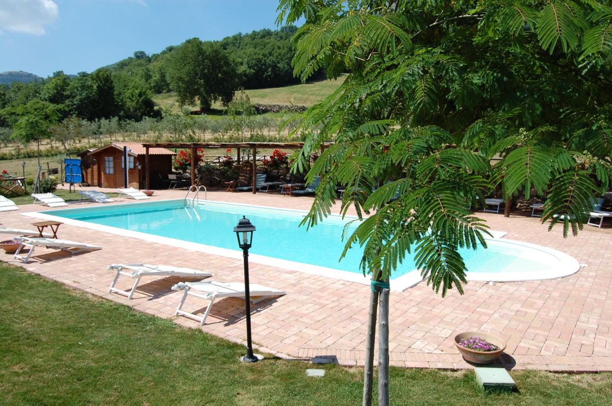 Enjoy a moment of peace by the pool, surrounded by nature at Agriturismo Santa Caterina.