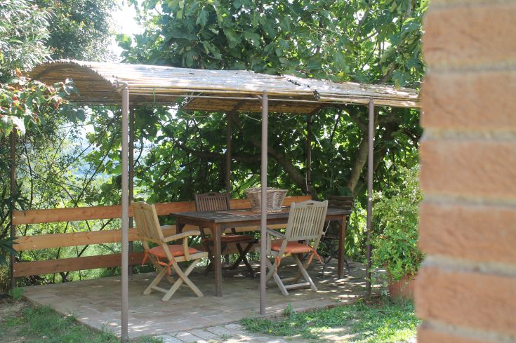 Une zone de repas sous un gazebo dans un jardin soigné, idéale pour se détendre à l'extérieur.