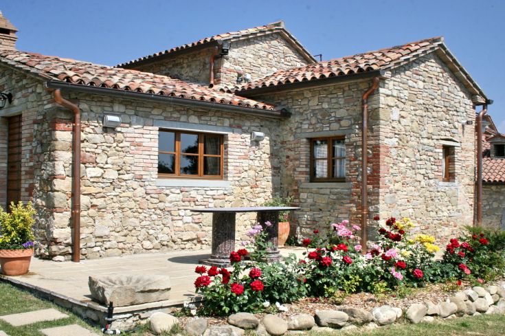 Steinbau mit blühenden Gärten, in einer gemütlichen Umgebung der umbrischen Landschaft gelegen.